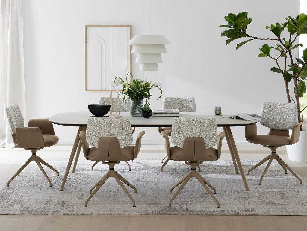 Musterring Esszimmer mit rundem Tisch, Stühlen, Pendelleuchte und abstraktem Wandbild.