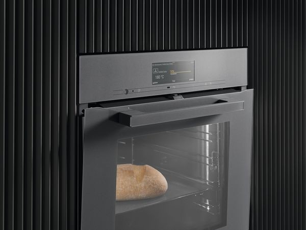Miele Backöfen mit TasteControl begeistern mit motorisch öffnenden und schließenden Backofentüren Miele Einbaubackofen - Nahansicht mit leicht geöffneter Backofentür