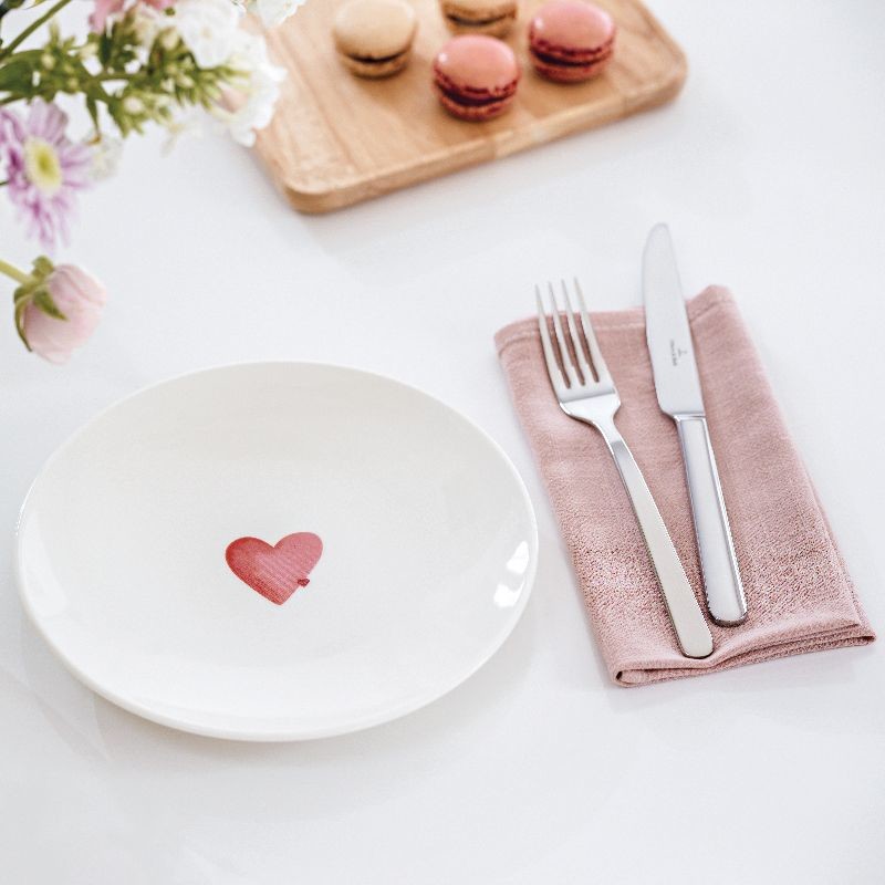 Festlich gedeckte Tafel mit Herz-Applikation, Serviette, Besteck und Macarons.