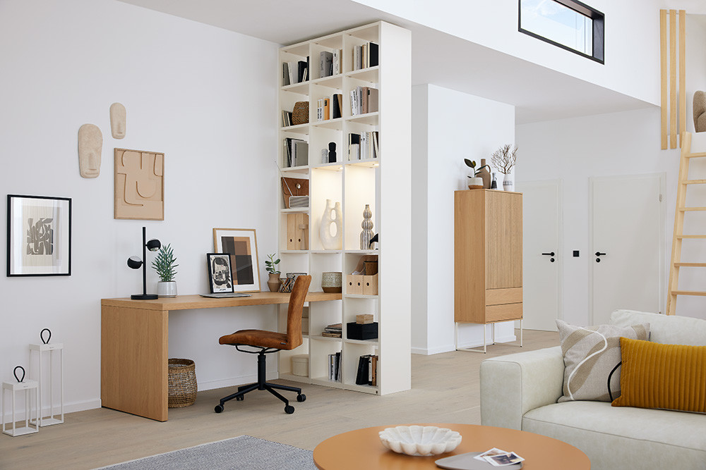 Moderner, heller Raum mit Schreibtisch, Musterring Regalen, Musterring Sofa und Treppe.