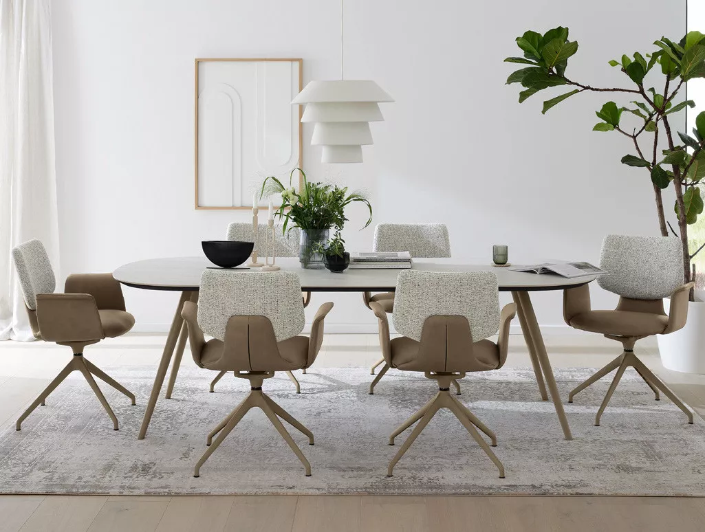 Musterring Esszimmer mit rundem Tisch, Stühlen, Pendelleuchte und abstraktem Wandbild.