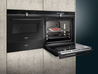 Dampfbackofen der Marke Siemens mit geöffneter Front und vakuumierten Gericht