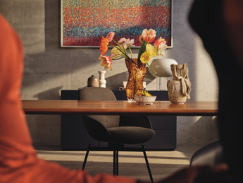 Esszimmermöbel von Rolf Benz Rolf Benz Esstisch mit Esszimmer-Polsterstuhl - Frontansicht mit Deko-Vase, Schale und Skulptur