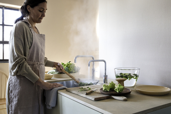 Frau koch mit Quooker Twintap Installation auf Küchenblock