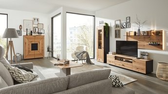 Interliving Wohnzimmer mit Anbauwand und Highboard dunkles Holz und schwarze Highlights